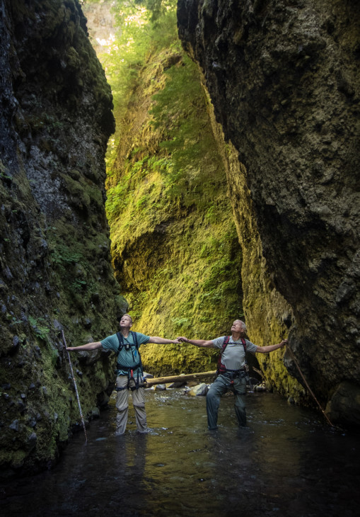 A slot canyon is casually defined as more narrow than tall. Sean Malone, left, and Mike Malone, right, stand at a point in the canyon where it is only two arm spans wide. Uncage The Soul/OPB