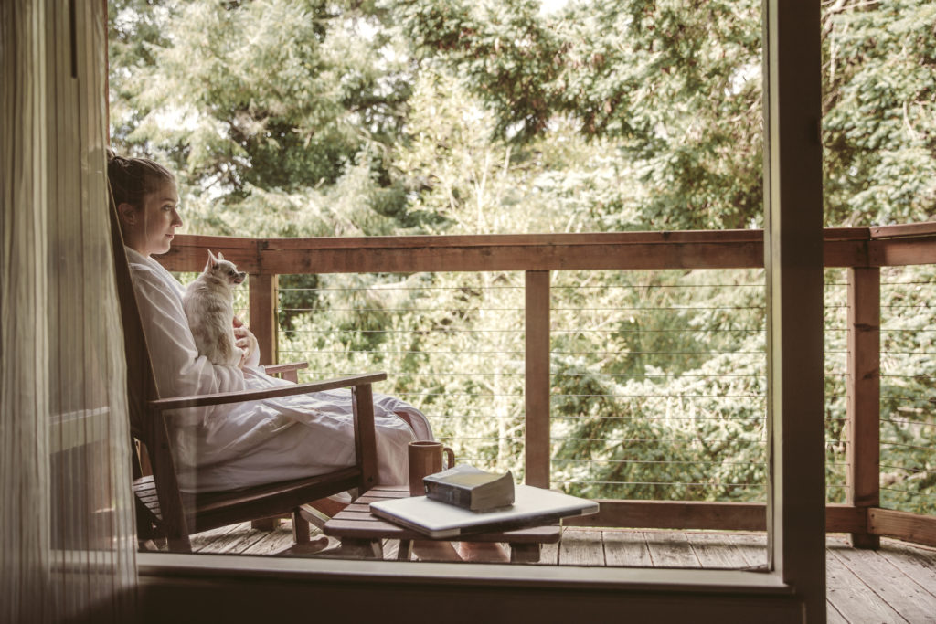 A woman relaxing on the patio of a private room at Salishan Coastal Lodge on the Oregon Coast