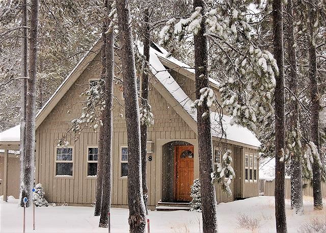 A cute little cabin surrounded by trees and snow in Sunriver Oregon.