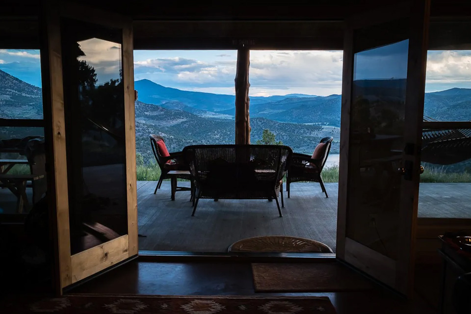 Looking out the open doors of the cabin to the front porch and high desert view