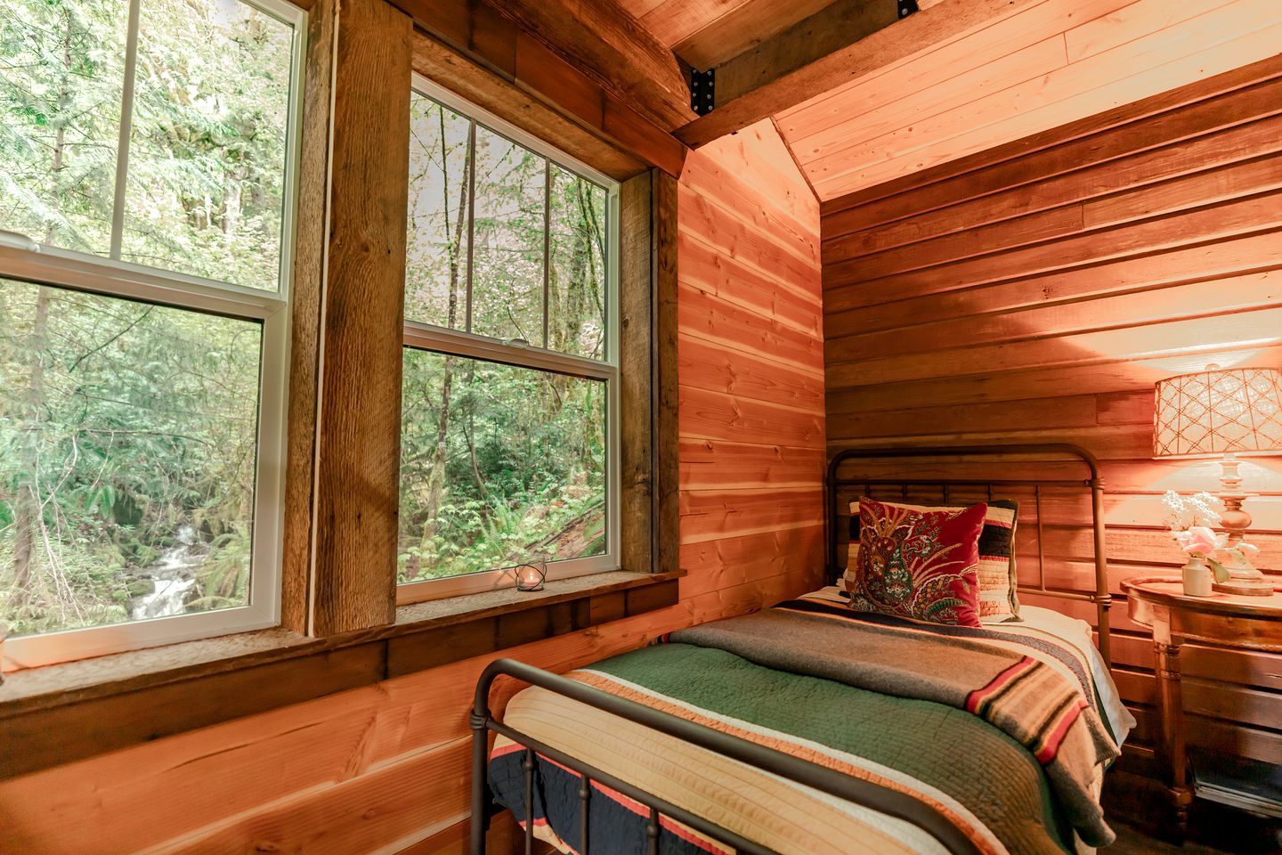The cabin interior with wood walls, a bed and window
