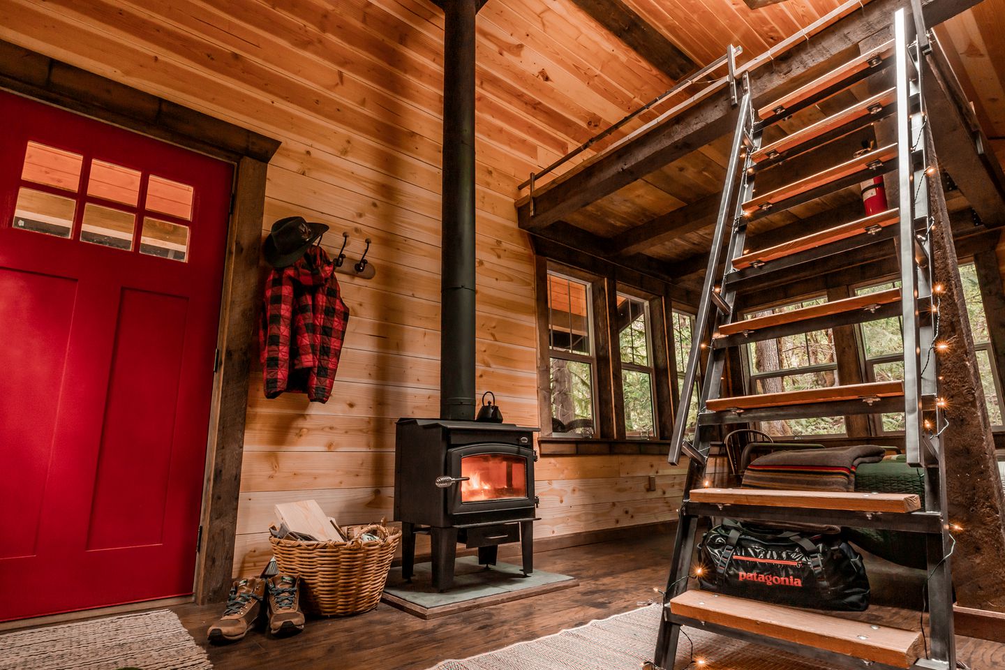 The cabin interior with the woodstove and ladder to the loft bed