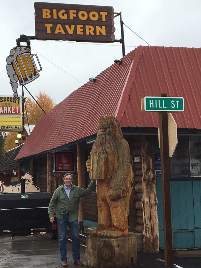 oregon senator jeff merkley next to carved bigfoot statue