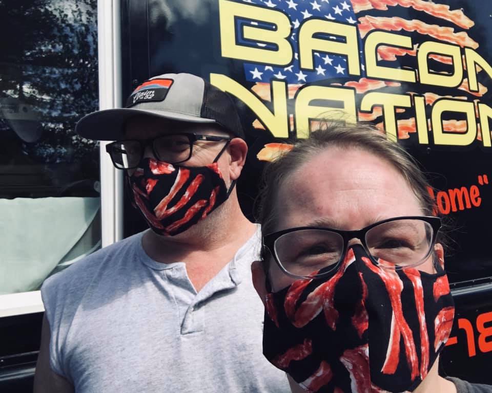 A man and a woman wearing bacon masks at the bacon nation food truck in eugene