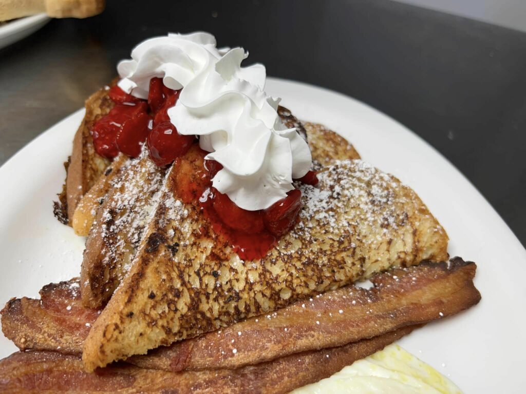 French toast with strawberries and whip cream.