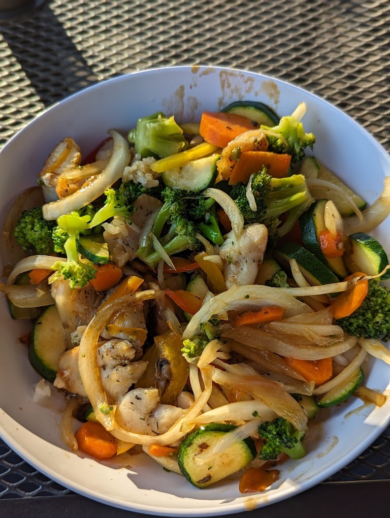 A colorful stir fry with lots of vegetables including zucchini and onion at Big Island Kona Mix plate.