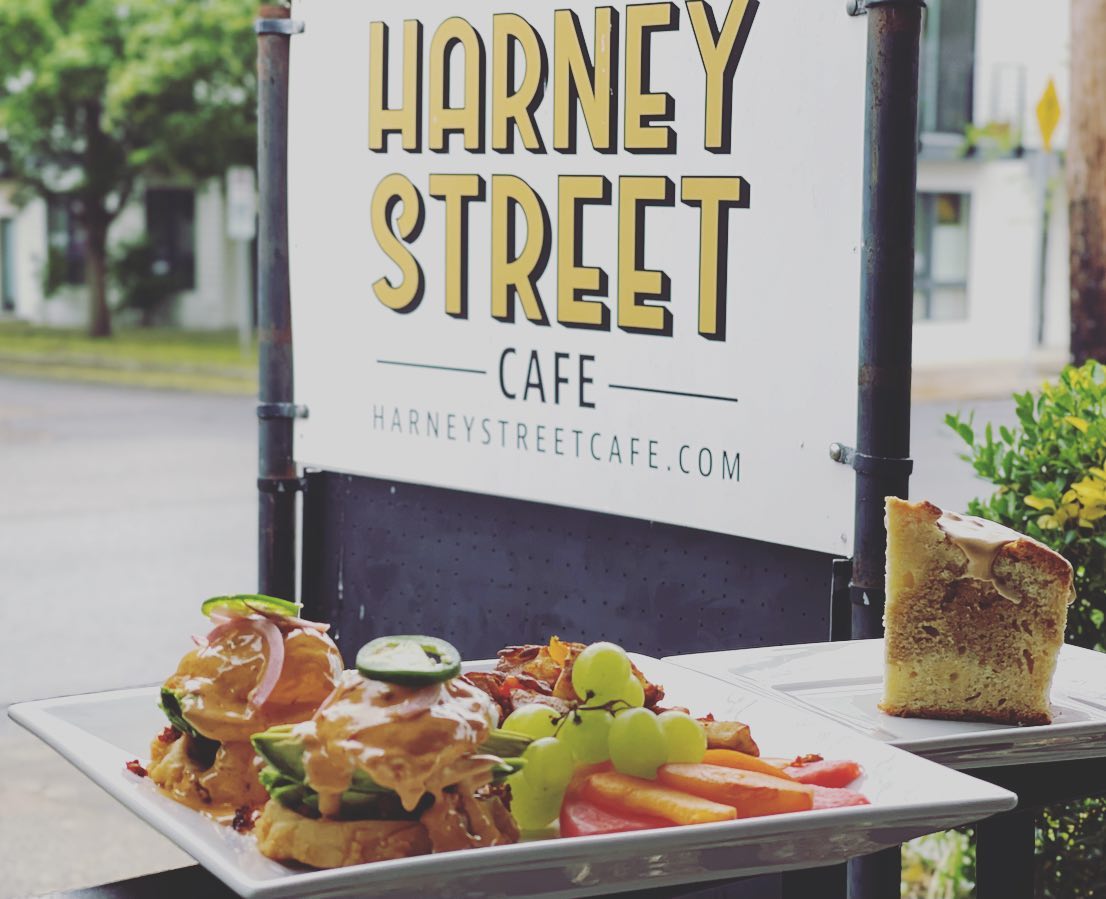A tasty looking plate of fresh food in front of the white and Black Harney Street Cafe sign.