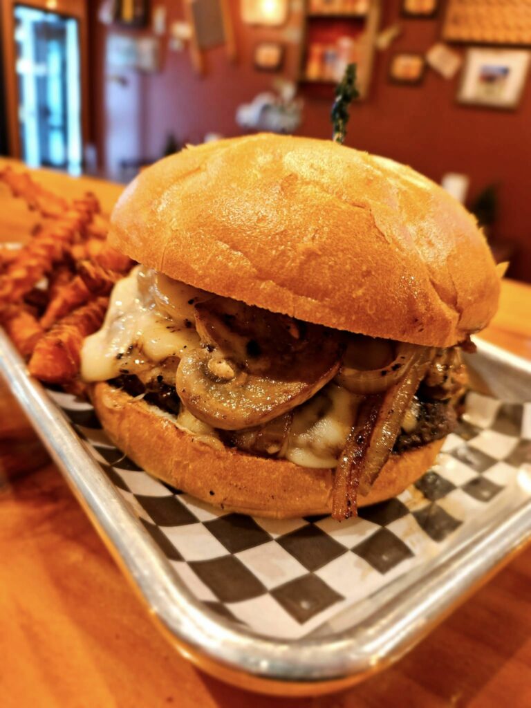 Mushroom Swiss Burger. It's sitting on a black and white checkered food wrapper.